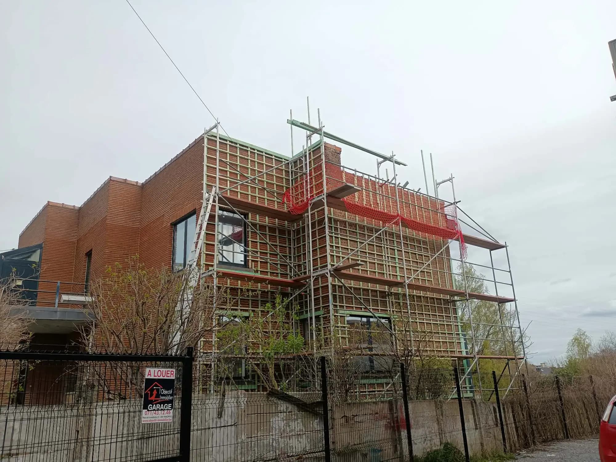 Échafaudage complet devant une maison en briques rouges
