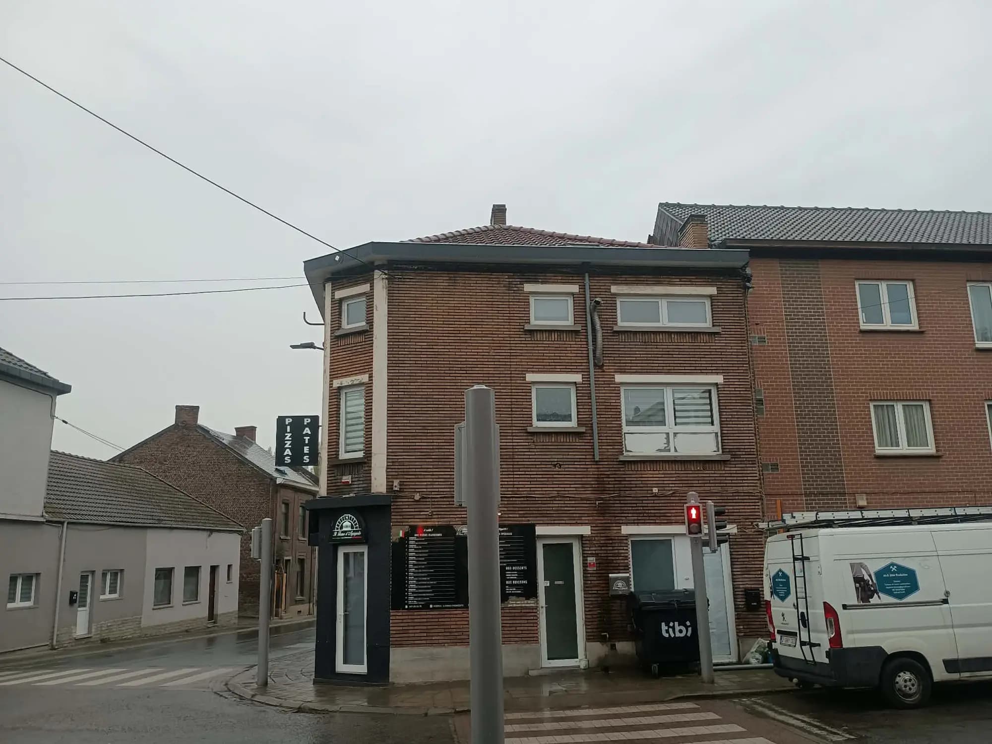 Immeuble d'angle à Charleroi avec la camionnette ALG DIM Evolution garée devant
