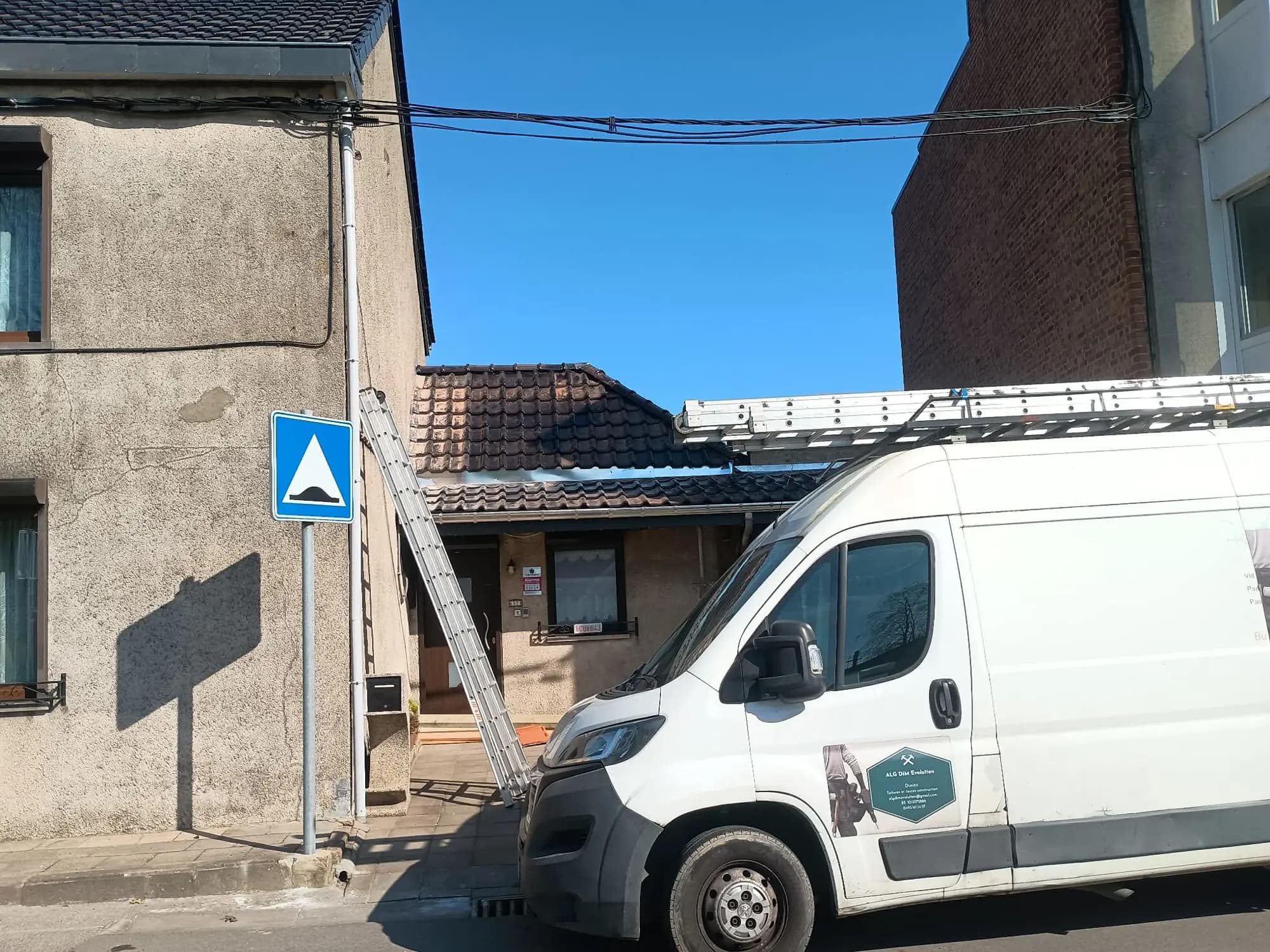 Camionnette et échelle devant une maison en chantier, toiture en cours
