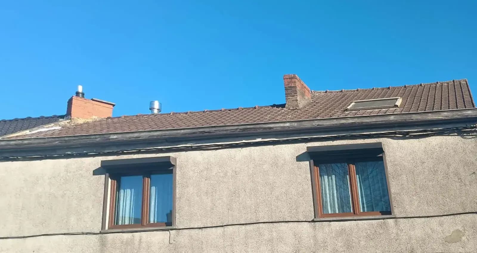 Toiture en tuiles brunes usées avant rénovation